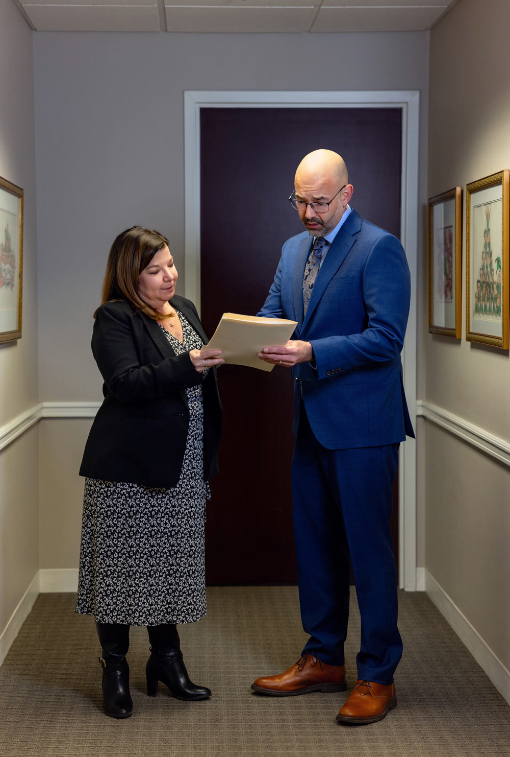 Attorneys converse over paperwork in hallway