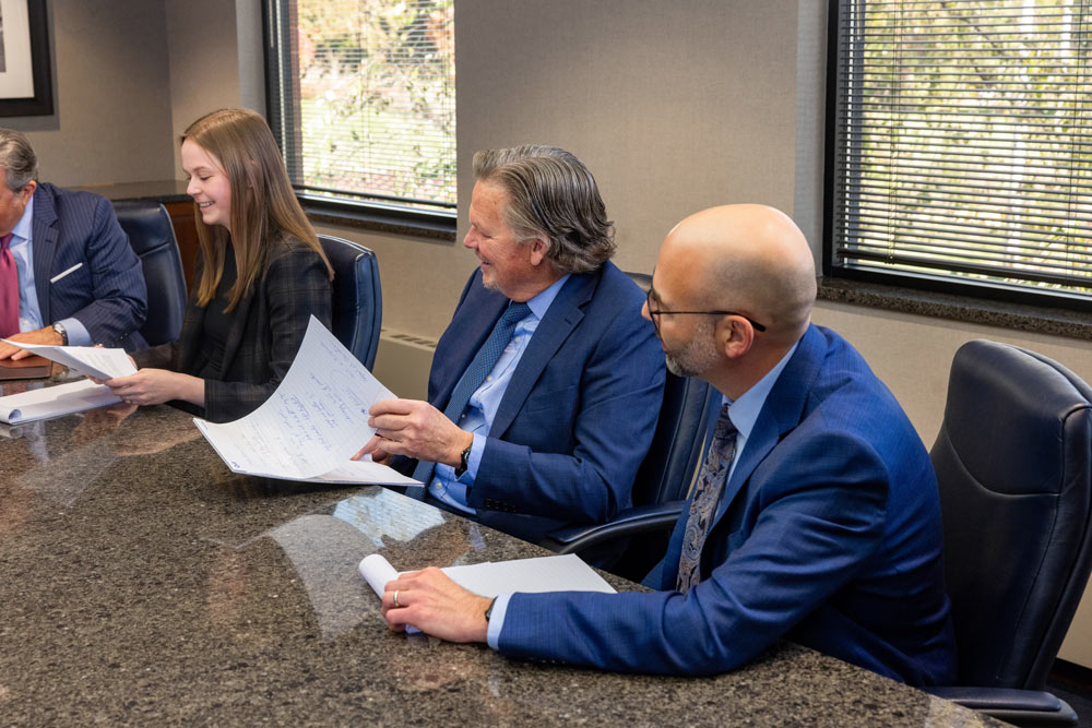 Attorneys smiling as they listen during meeting at conference table Attorneys smiling as they listen during meeting at conference table