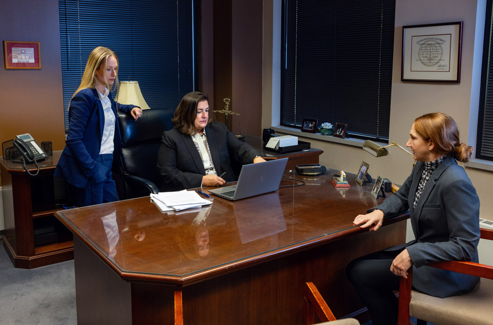 Lawyer at desk discussing case matters with council Lawyer at desk discussing case matters with council