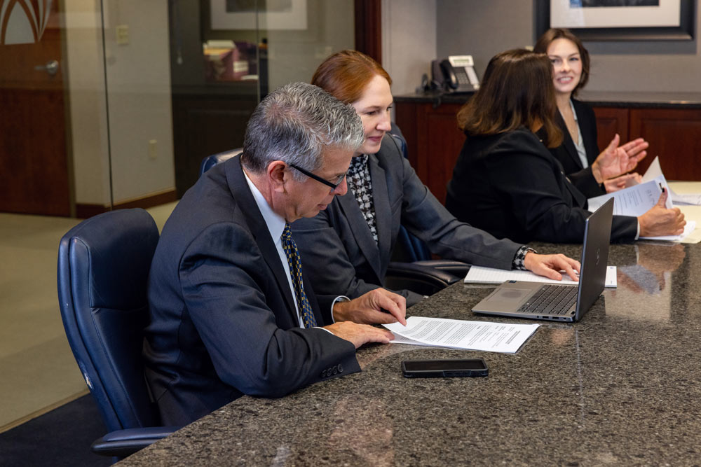 Legal council looks through evidence and paperwork at table Legal council looks through evidence and paperwork at table